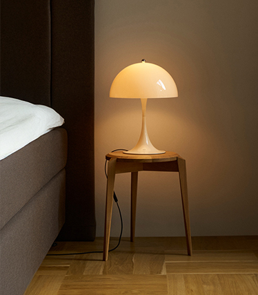 Classic mushroom table lamp provides soft lighting in a cosy bedroom