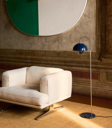 Elegáns &Tradition állólámpa modern lounge fotel mellett egy hangulatos enteriőrben.