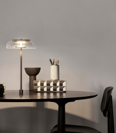 Elegáns asztali lámpa modern íróasztalon stílusos lakáskiegészítőkkel.